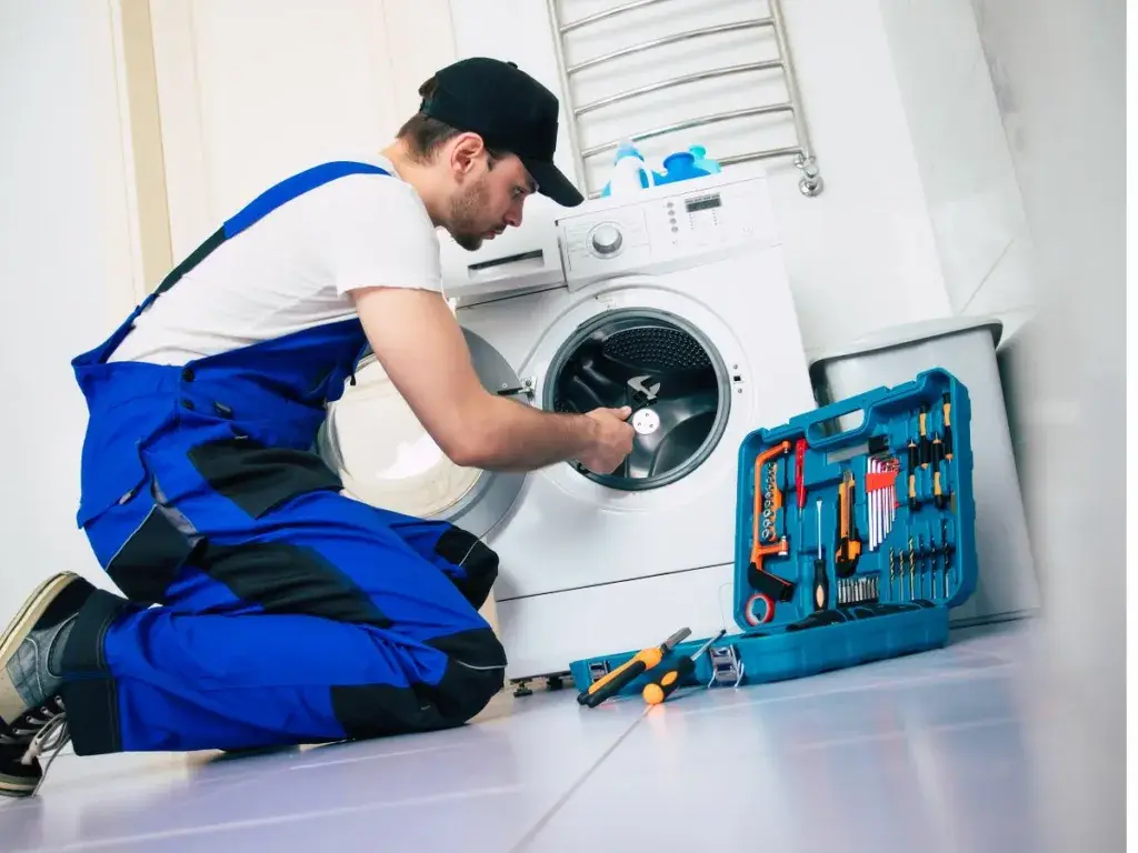 Tumble dryer being repaired by a qualified technician